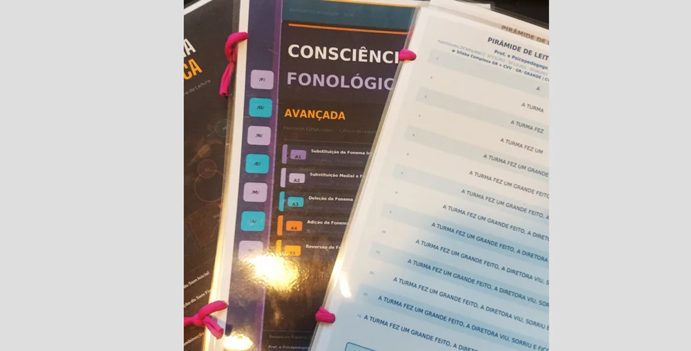 Criança utilizando material impresso personalizado durante aula particular de alfabetização